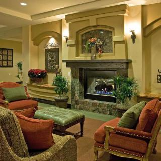 A cozy living room with a fireplace, warm lighting, and comfortable furniture.