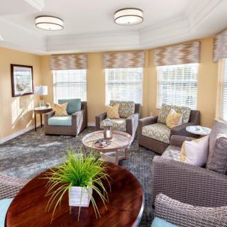 A cozy living room with ample seating and natural light streaming through large windows.