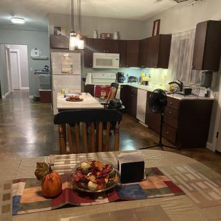 A modern kitchen and dining area with wooden cabinets, an island counter, and cozy decor.