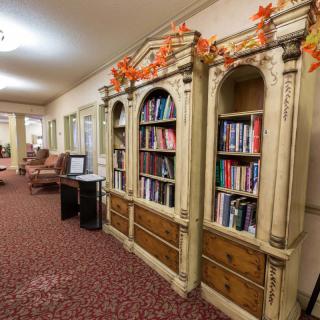 A cozy hallway with a decorative bookshelf adorned with autumn leaves.