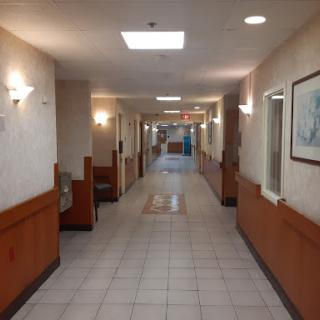 A well-lit corridor with wooden accents and tiled flooring.