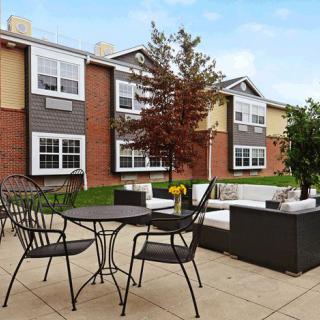 Outdoor patio area with furniture in front of an apartment building.