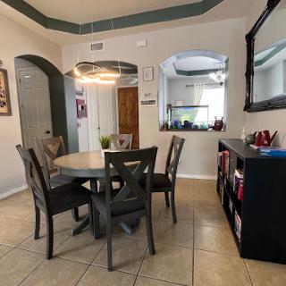 A cozy dining area featuring a round table surrounded by stylish chairs, perfect for family meals.