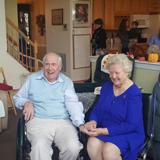 A cheerful elderly couple enjoying time together in a cozy living room.
