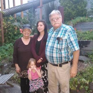 A family group photo taken in a garden setting.