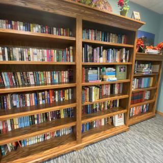 A cozy library with wooden bookshelves filled with a variety of books.