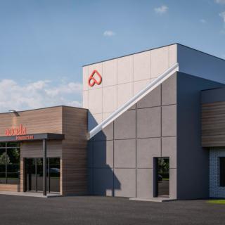 A modern commercial building with a sleek design under a clear sky.
