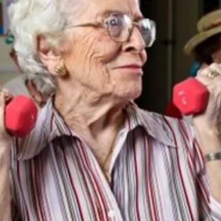 An elderly woman lifting dumbbells, showcasing an active and healthy lifestyle.