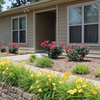 A charming house with a vibrant garden showcasing blooming flowers and a welcoming front entrance.
