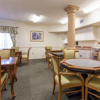 A well-furnished dining room with multiple tables and chairs, featuring a classic interior design.