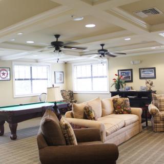 A spacious living room featuring a pool table and comfortable seating area.