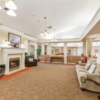 A spacious and elegantly decorated living room with a fireplace, comfortable sofas, and warm lighting.