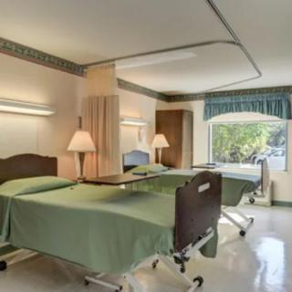 A clean and well-organized hospital room with two beds.