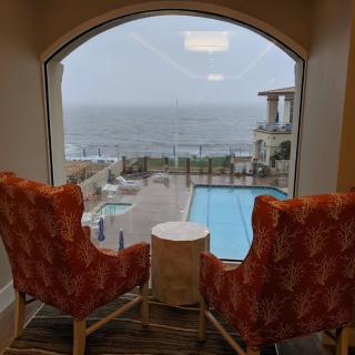 A cozy indoor seating area with a view of the pool and ocean beyond.
