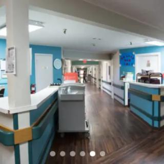 A hospital corridor with reception desks and medical equipment.