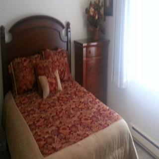 A cozy bedroom with a single bed adorned with floral bedding and matching pillows.