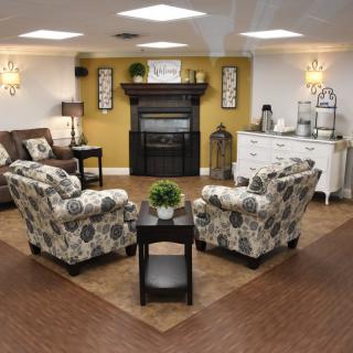 A cozy and modern living room with a centered seating area around a fireplace.