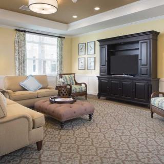 A cozy and stylish living room with elegant furniture and a large entertainment center.