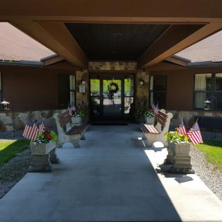 Entrance of a building decorated with American flags and benches on either side.