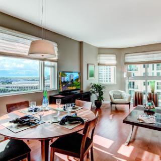A bright and modern living space featuring a dining area with windows that offer a scenic view.