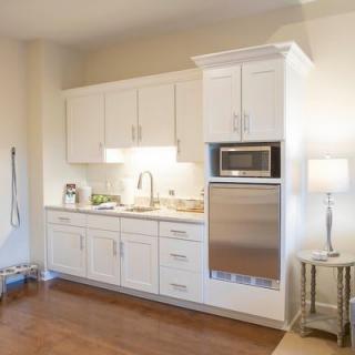 A modern kitchen with white cabinets and built-in appliances.