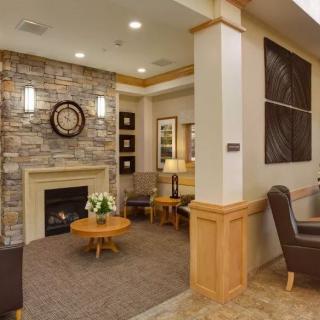A cozy living room with a stone fireplace, modern furniture, and warm lighting.