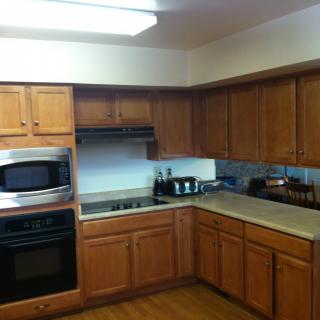 A kitchen with wooden cabinets and various appliances including an oven, microwave, and stove.