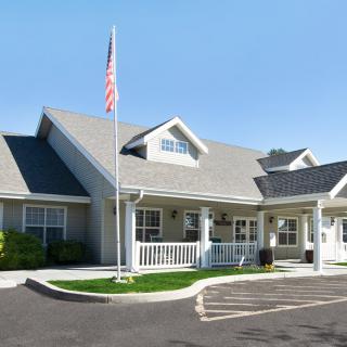 A residential building with a front porch and an American flag.