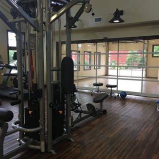 A well-equipped gym area featuring various exercise machines and weights.