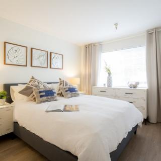 A modern and cozy bedroom with stylish decor and ample natural light.