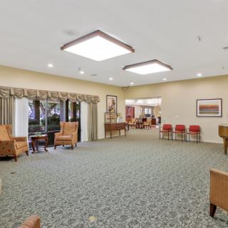 A spacious and well-lit lobby with comfortable seating areas and carpeted flooring.