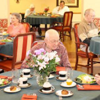 Seniors enjoying a meal together in a communal dining setting.