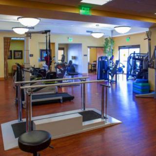 A well-equipped gym with various fitness machines and rehabilitation equipment.