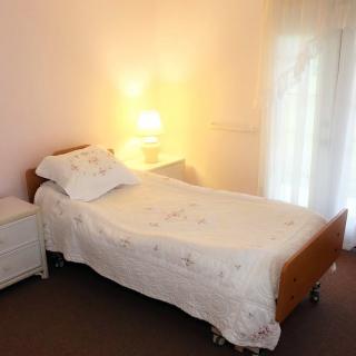 A cozy bedroom with a single bed and a softly lit lamp.