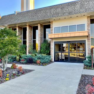 Entrance of a modern building with landscaped surroundings.