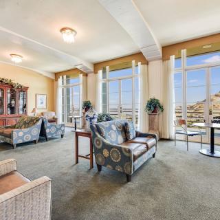A spacious living room with large windows, allowing ample natural light to fill the space, featuring comfortable seating and elegant decor.