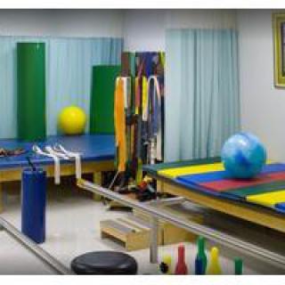 A well-equipped physical therapy room with exercise mats and therapy balls.