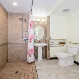 A modern bathroom featuring a shower, toilet, and sink with elegant tile work.