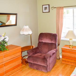 A cozy living room with a comfortable armchair and elegant wooden furniture.
