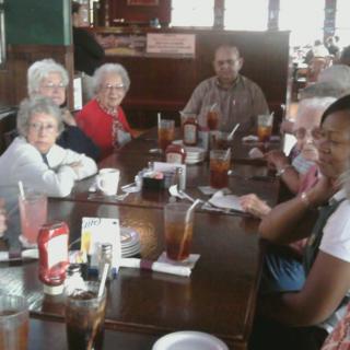 A group of people gathered around a table at a restaurant.