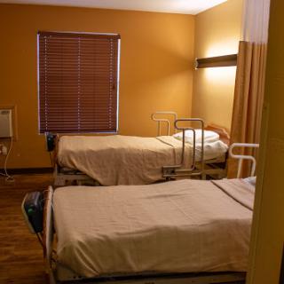 A simple and clean patient room with two hospital beds.
