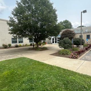 A view of a well-maintained building surrounded by greenery and landscaping.