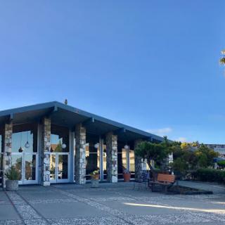 A modern building with a spacious entrance set against a clear blue sky.