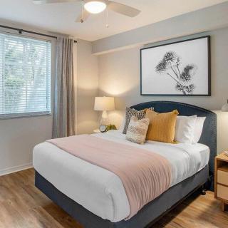 A cozy and modern bedroom with a neatly made bed, stylish artwork, and warm lighting.