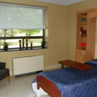 A hospital room with a bed and window view.