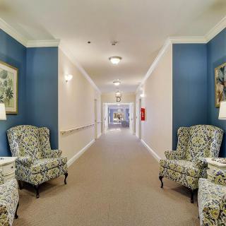 A well-lit hallway with decorative chairs and elegant interior design.