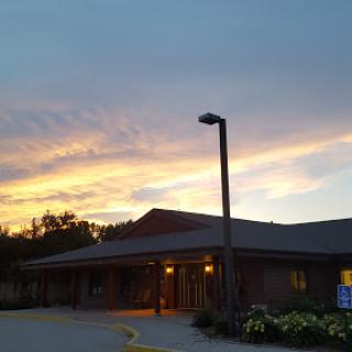 A tranquil evening view showcasing a building under a colorful sunset sky.