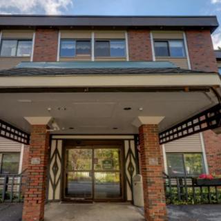 The image shows the entrance of a brick building with large windows above.