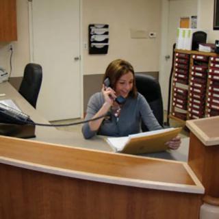 A receptionist answering a call at her office desk.