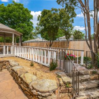 A picturesque backyard featuring a gazebo and landscaped stone pathways.